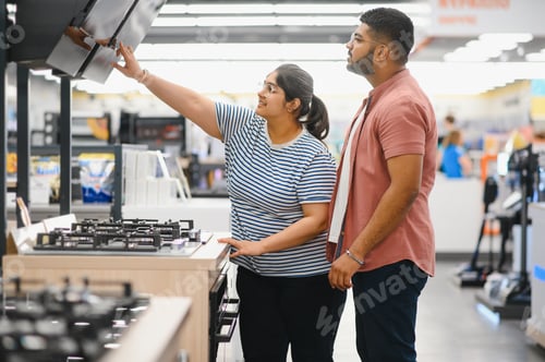 Preview: Young indian couple choosing new gas stove in home appliances store