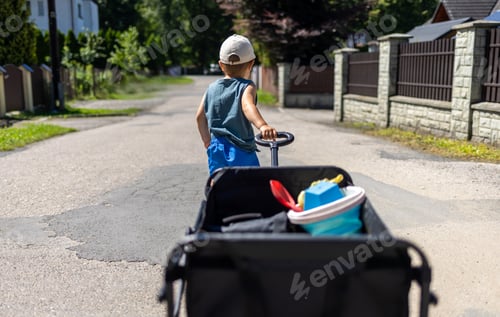 Preview: Child pulls a four-wheel folding wagon with toys and accessories during a tourist trip