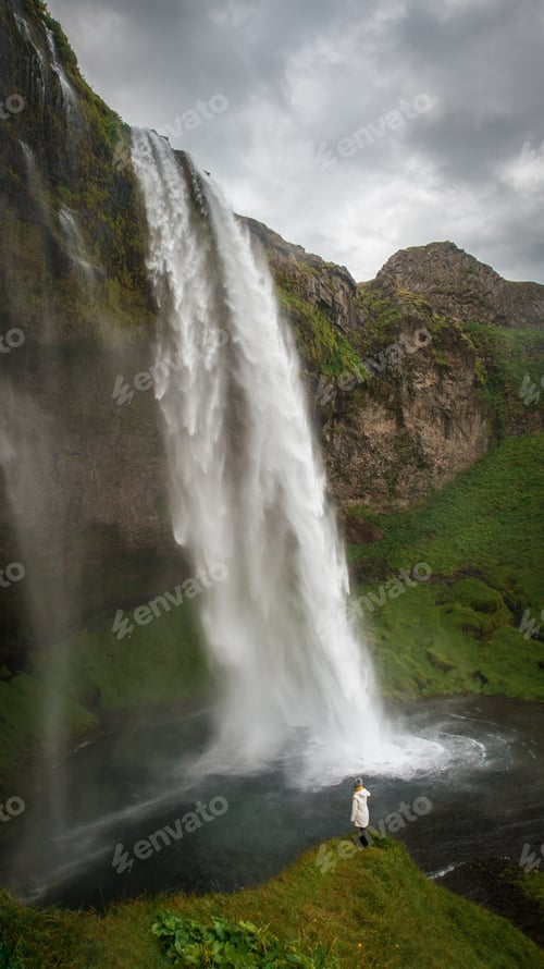 Preview: Woman stay on waterfall in Iceland, hide waterfall in Iceland, a