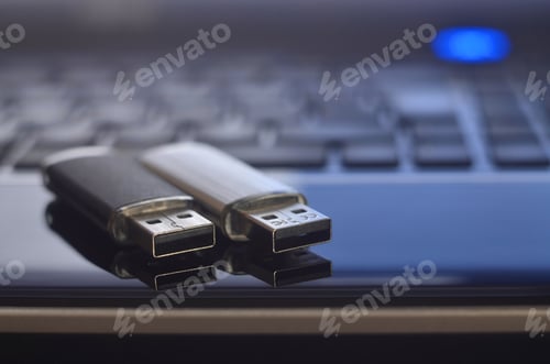 Preview: USB flash cards lying on black laptop case in front of his keyboard