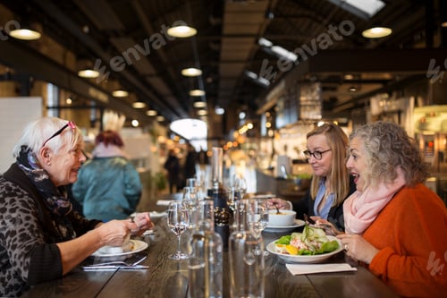 Preview: Three women having lunch in restaurant