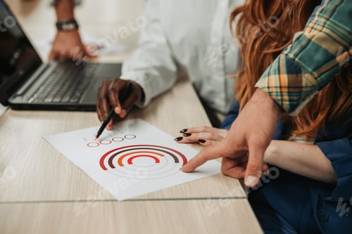 Preview: Diverse people hands pointing on a chart on a desk in an office