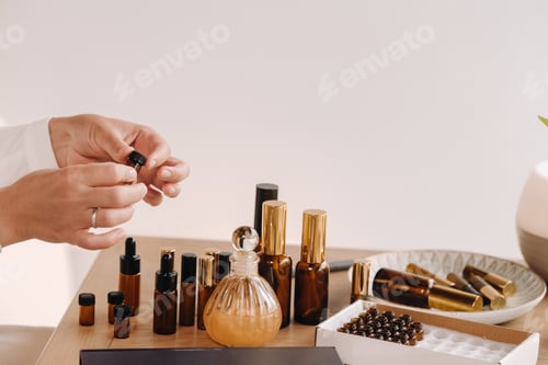 Preview: Close-up of a Woman's hands applying essential oil on her wrist indoors