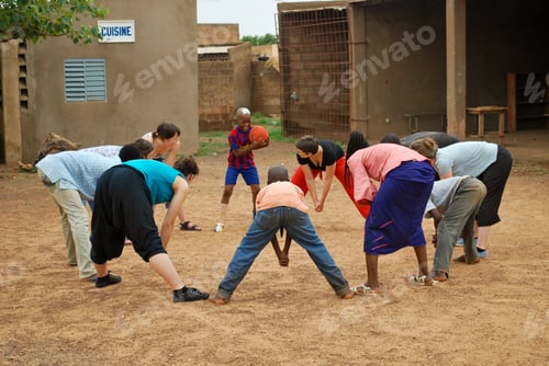 Preview: Young black African boys and teachers playing a game outdoors - youngsters Chinese soccer