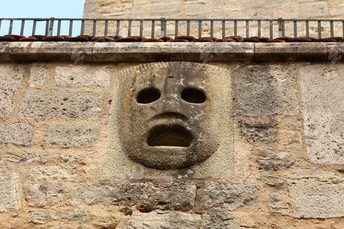 Preview: Low angle shot of a concrete face statue on the wall in Rothenburg ob der Tauber, Bavaria, Germany