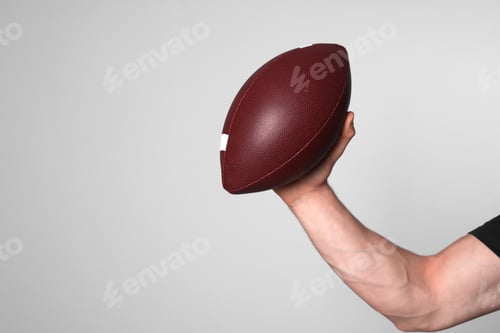Preview: Man with American football ball on light grey background, closeup. Space for text
