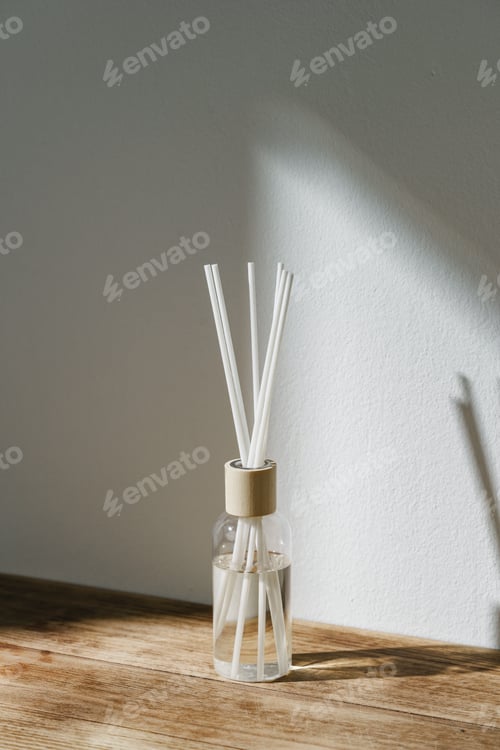 Preview: Sunlit Diffuser Bottle With Reeds Casting Shadows on a White Wall
