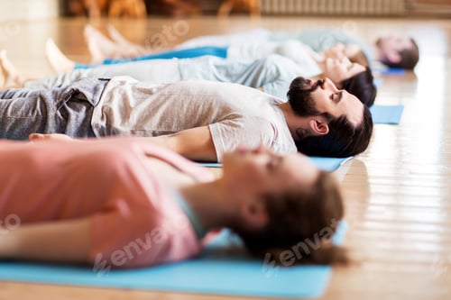 Preview: group of people making yoga exercises at studio