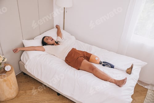 Preview: Happy woman prosthetics bionic leg wakeup in the morning at lovely home bed carefree strong healthy