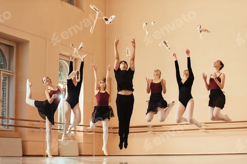 Preview: Large group of happy ballet dancers jumping and throwing their ballet shoes in the air.