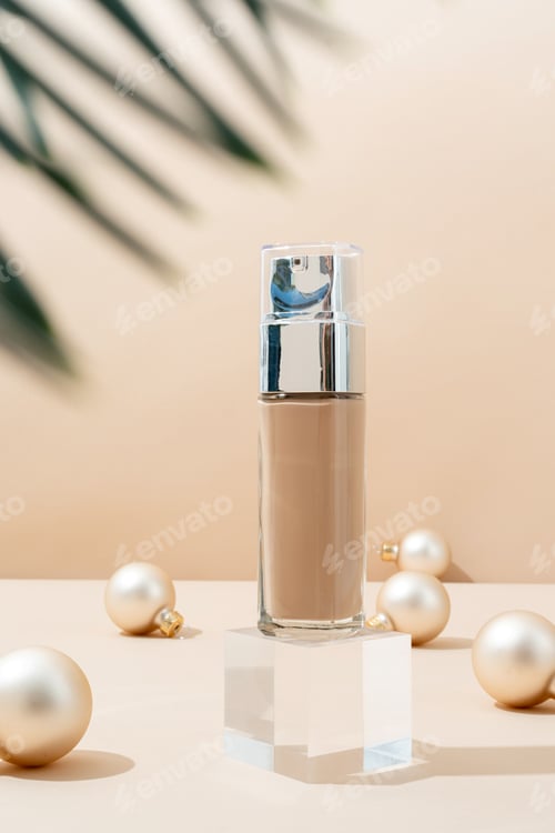 Preview: A minimalistic scene of foundation bottle on glass podium with christmas decorative balls and pine
