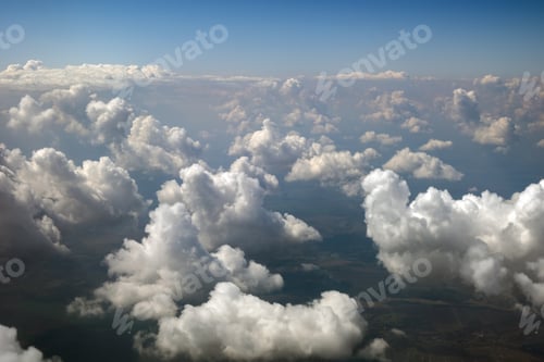 Preview: Aerial view from airplane window of white puffy clouds on bright sunny day