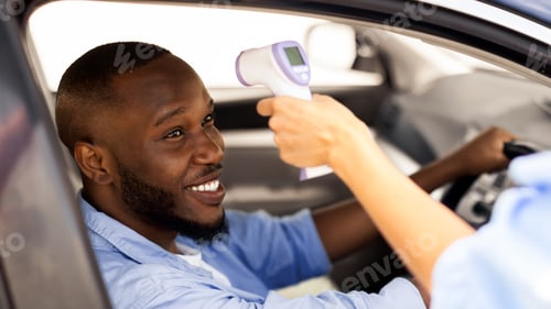 Preview: Medical Worker Checking Body Temperature Of Black Man Driving Car