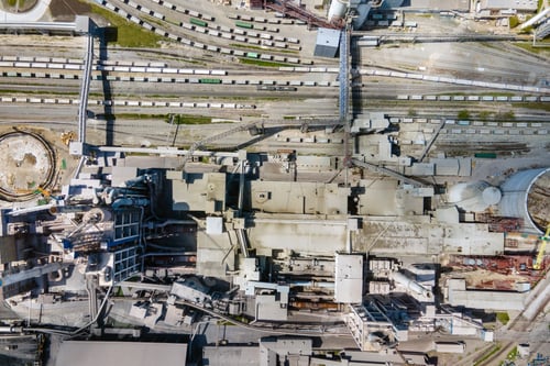 Preview: Aerial view of cement plant with high concrete factory structure and tower crane at industrial