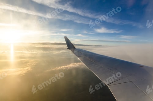 Preview: Airplane wing over serene sky at sunset