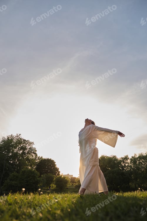 Preview: Woman in White Dress Enjoys Sunrise in Park