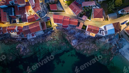 Preview: Drone shot of colorful houses on the rocky coast of Corrubedo natural park in Galicia, Spain