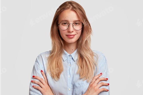 Preview: Pleasant looking self assured female student in stylish shirt and eyewear, looks directly at camera,