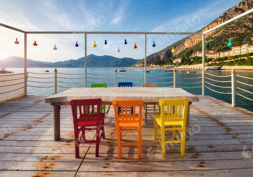 Preview: Beautiful cafe on wooden pier on the sea at sunset in summer.
