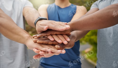 Preview: Closeup shot of a group of unrecognisable men joining their hands together in a huddle