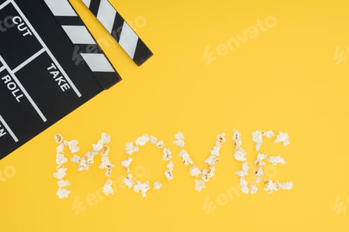 Preview: clapperboard and 'movie' lettering made with popcorn isolated on yellow