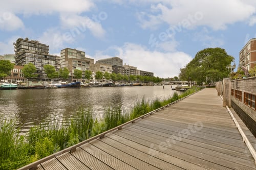 Preview: a boardwalk overlooking a river with boats and buildings