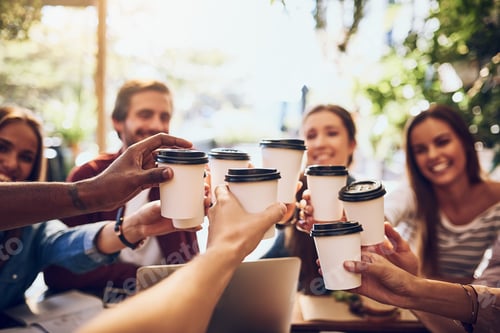 Preview: Cropped shot of a group of friends toasting with cups of coffee while out together