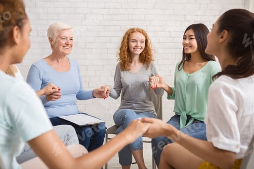 Preview: Smiling Diverse Women Sitting In Circle During Group Therapy Indoor