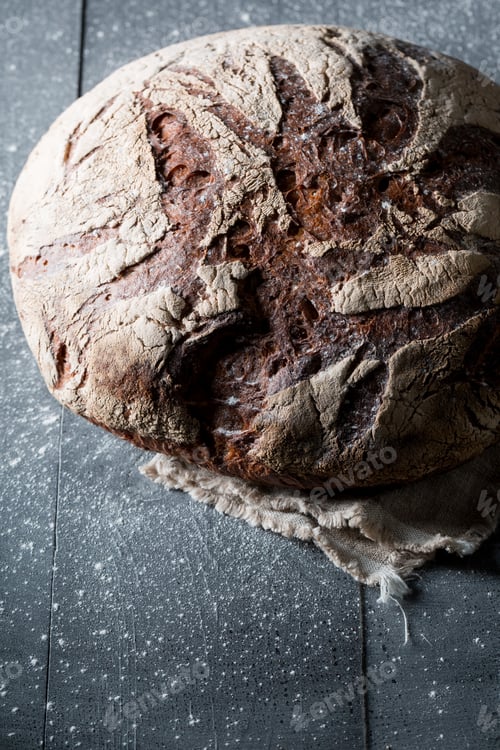Preview: Tasty loaf of bread with whole grains on dark table