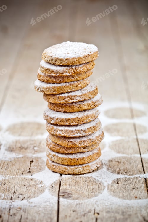Preview: Fresh oat cookies stack with sugar powder closeup on rustic wooden table.