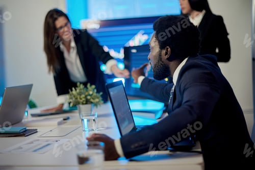 Preview: Crop multiracial employees working at table with laptops in office