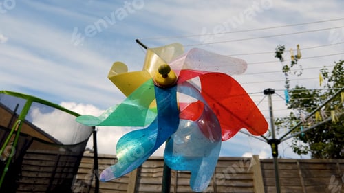 Preview: Rainbow Coloured Windmill Fan In A Suburban Garden In The Uk, Taken On A Funny Day With A