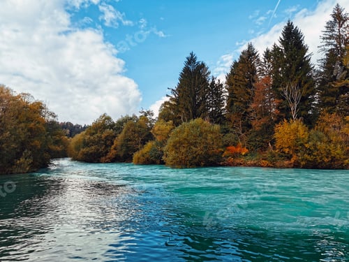 Preview: Autumn landscape with trees on bank of emerald river.