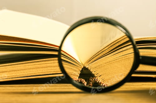 Preview: Vintage book and magnifying glass on wooden desk