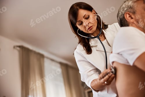 Preview: A male patient is checked up by a female doctor who uses a stethoscope.