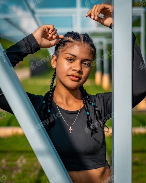 Preview: Vertical of a beautiful young woman in a black shirt posing outdoors