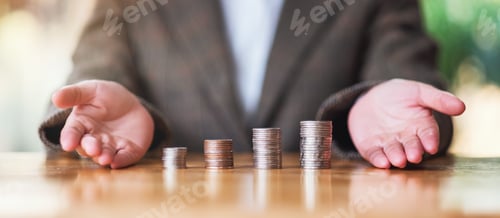 Preview: Businesswoman showing stack of coins on the table for saving money concept