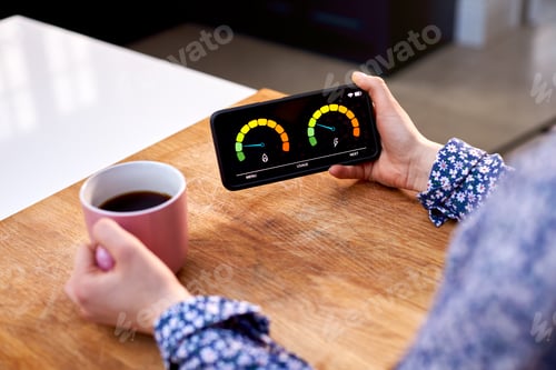 Preview: Close Up Of Woman Holding Smart Energy Meter In Kitchen Measuring Domestic Electricity And Gas Use
