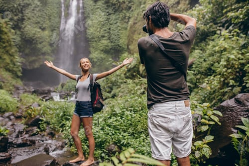 Preview: Photographer taking photos of a woman near waterfall