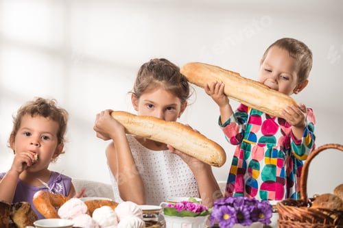 Preview: Funny little children eat fresh bread and rolls