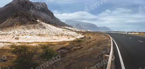 Preview: Winding road leads along breathtaking coastline past black volcano and white sand dunes. North of