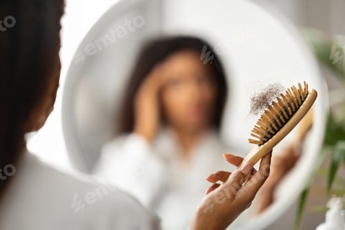 Preview: Hairloss. Upset Black Woman Holding Comb Full Of Fallen Hair After Brushing