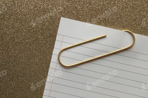 Preview: Gold glitter background with note paper and gold paperclip