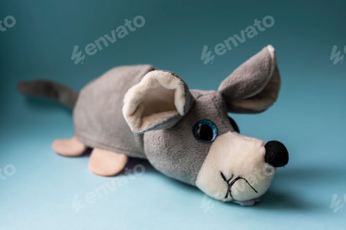 Preview: Plush toy gray dog on a blue background. Indoors, day light Front view.