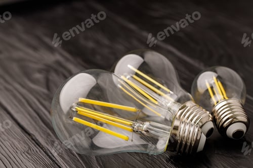 Preview: Light bulbs on dark wooden background close up