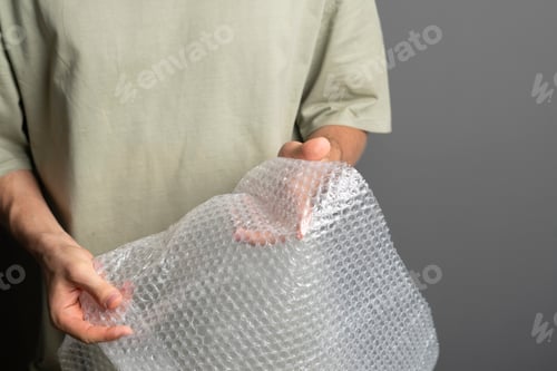 Preview: a person holding and bursting bubble protective wrap trying to calm down