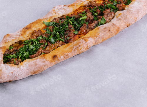 Preview: Traditional turkish pide with minced meat and herbs on parchment paper