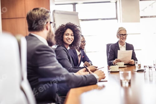 Preview: Businesswomen and men talking at conference table meeting