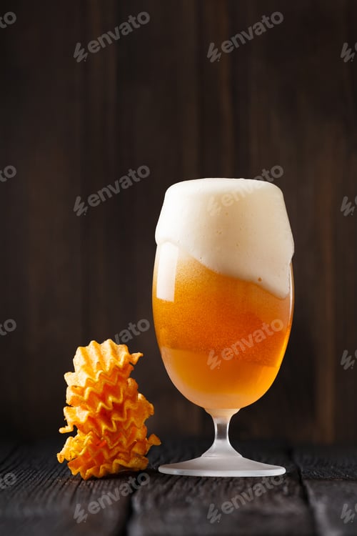 Preview: Beer in a glass and chips on a dark wooden background