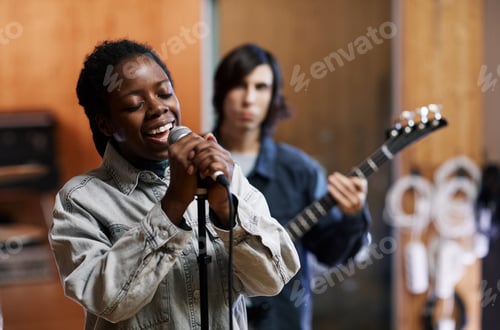 Visualização: Jovem mulher cantando com banda em estúdio